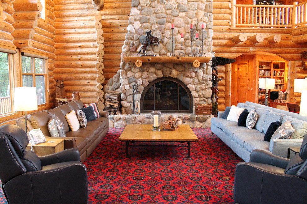 This is an example of a large rustic games room in Grand Rapids with carpet, a standard fireplace, a stone fireplace surround and red floors.