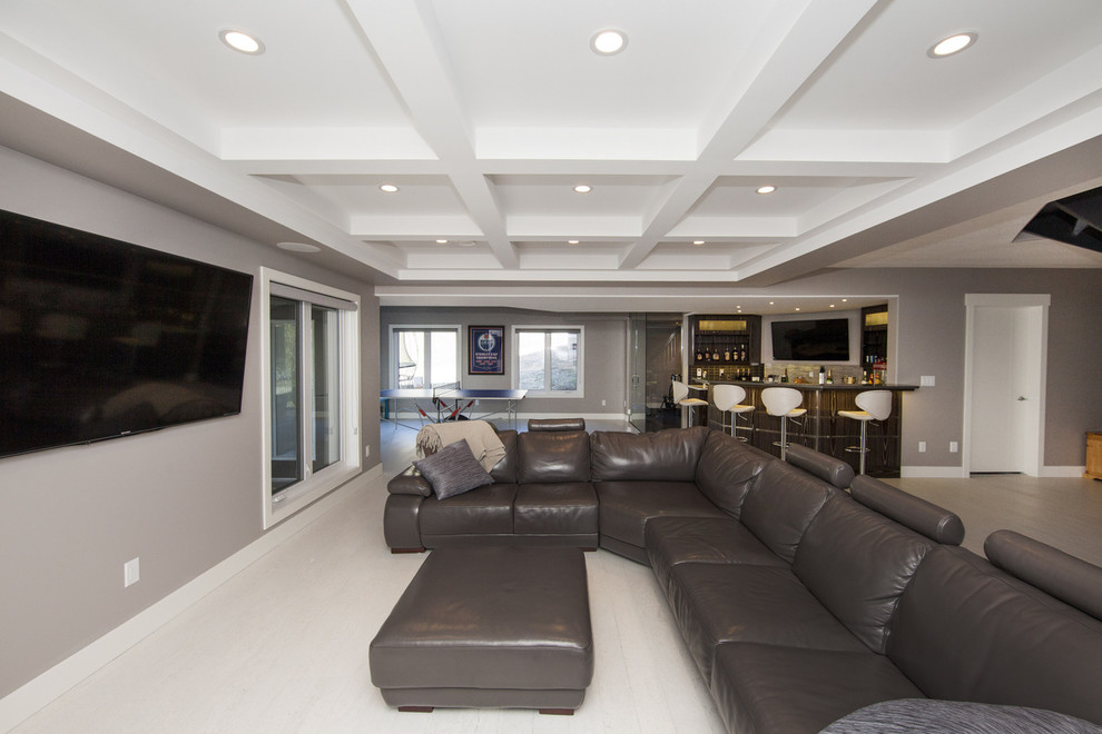 Example of a large trendy open concept carpeted family room design in Edmonton with a bar, gray walls and a wall-mounted tv