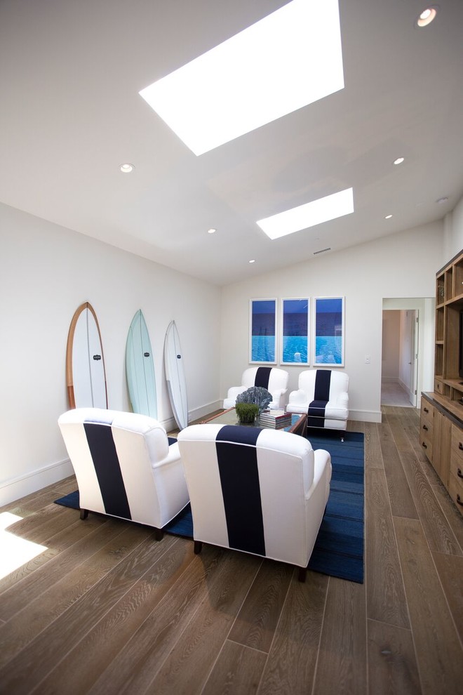 Mid-sized beach style enclosed dark wood floor and brown floor family room photo in Orange County with white walls and a media wall