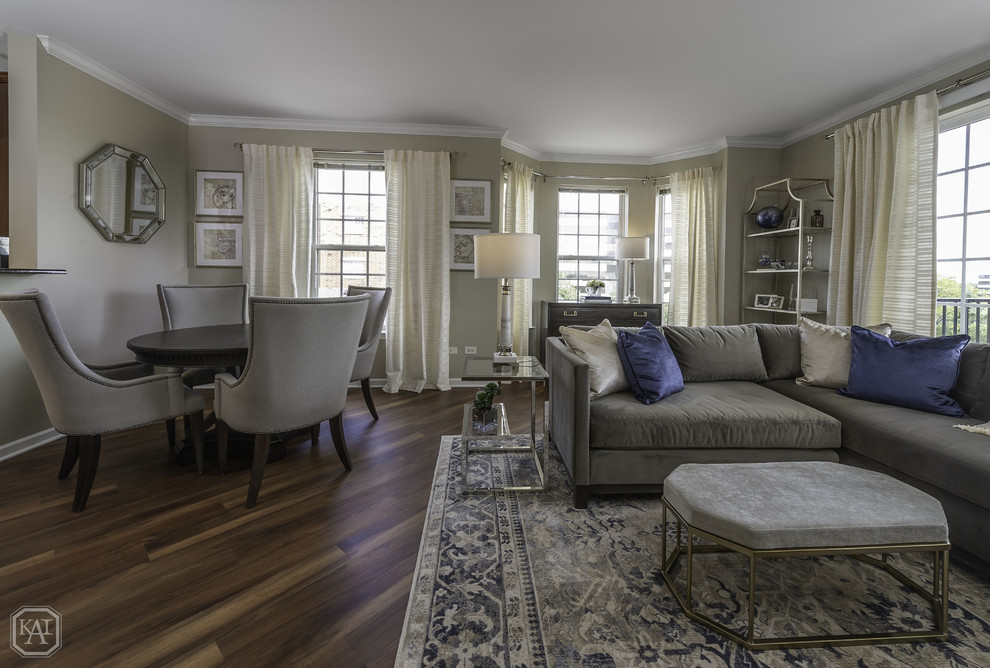 Foto de sala de estar abierta clásica renovada de tamaño medio sin chimenea con paredes grises, suelo laminado, televisor independiente y suelo marrón