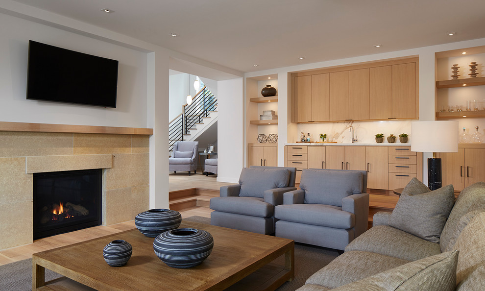 Example of a transitional light wood floor family room design in Minneapolis with white walls, a standard fireplace, a stone fireplace and a wall-mounted tv