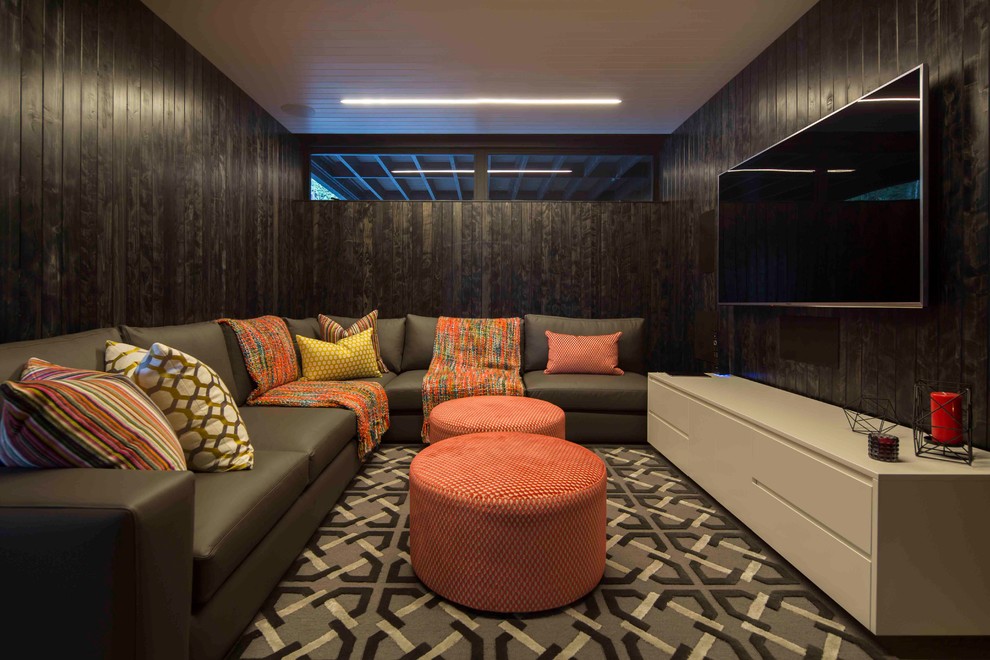 Cette photo montre une salle de séjour tendance de taille moyenne et fermée avec un mur noir, moquette, un téléviseur fixé au mur et un sol gris.