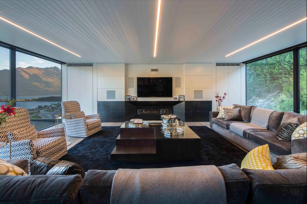 Свежая идея для дизайна: изолированная гостиная комната в современном стиле с белыми стенами, горизонтальным камином и телевизором на стене - отличное фото интерьера