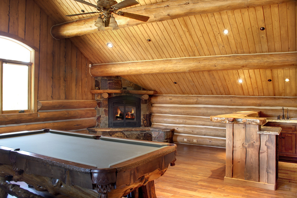 Inspiration for a medium sized rustic enclosed games room in Atlanta with a home bar, brown walls, medium hardwood flooring, a corner fireplace, a stone fireplace surround, no tv and brown floors.