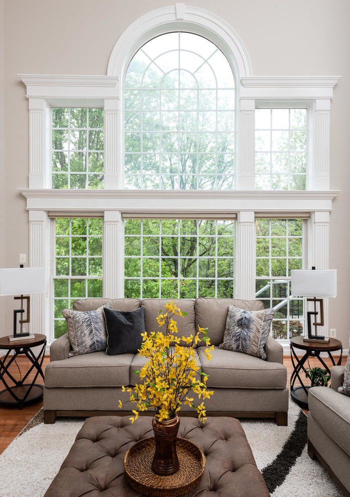 Imagen de sala de estar abierta clásica renovada grande con paredes grises, suelo de madera en tonos medios y suelo marrón