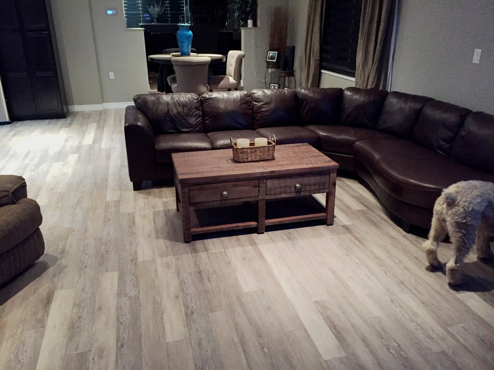 Ejemplo de sala de estar abierta tradicional de tamaño medio con paredes grises, suelo de madera clara y suelo gris