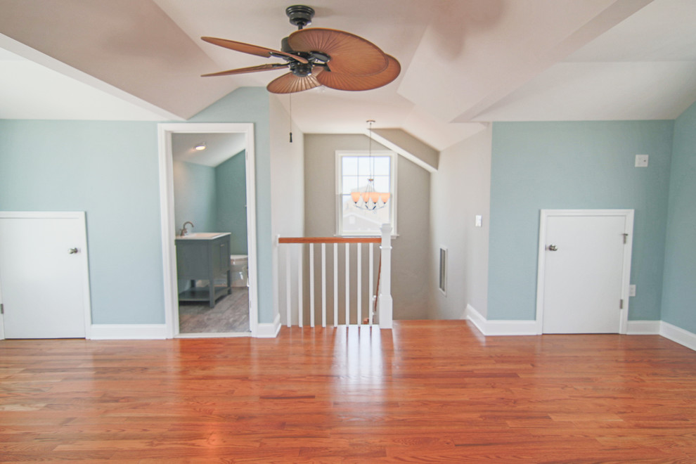 Imagen de sala de estar abierta marinera de tamaño medio sin chimenea con paredes grises y suelo de madera clara