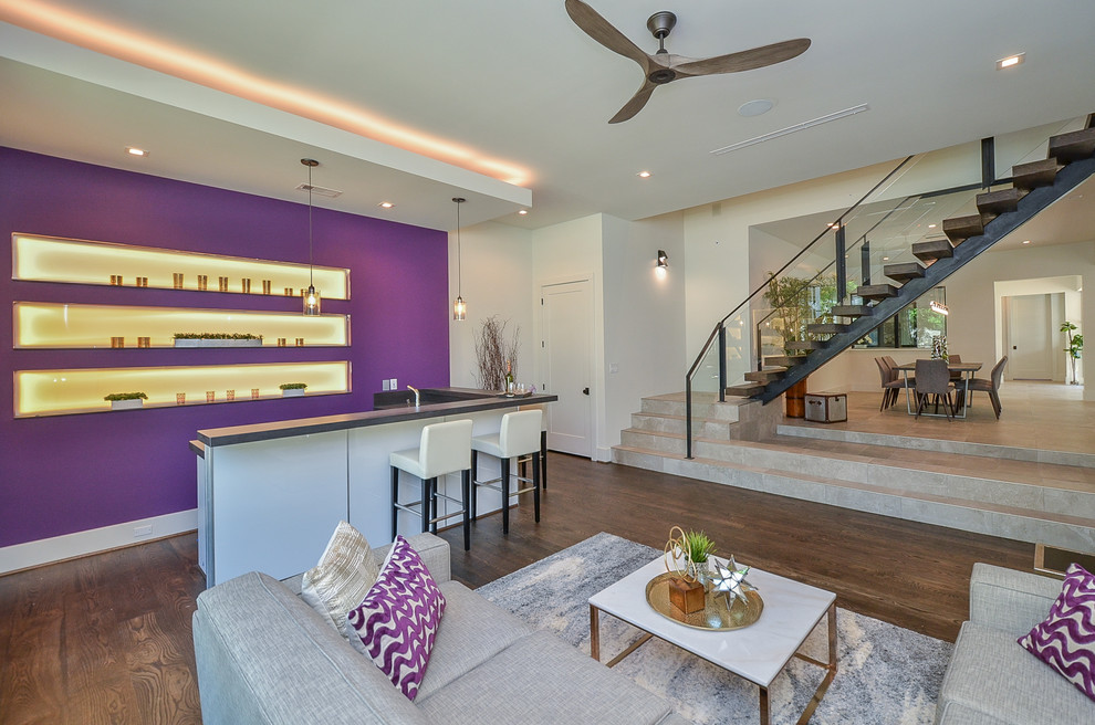 Foto de sala de estar con barra de bar abierta minimalista de tamaño medio sin chimenea y televisor con paredes púrpuras, suelo de madera en tonos medios y suelo marrón