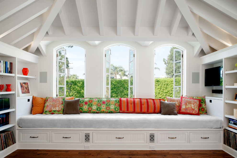 Foto de sala de estar clásica con paredes blancas, suelo de madera en tonos medios y televisor colgado en la pared