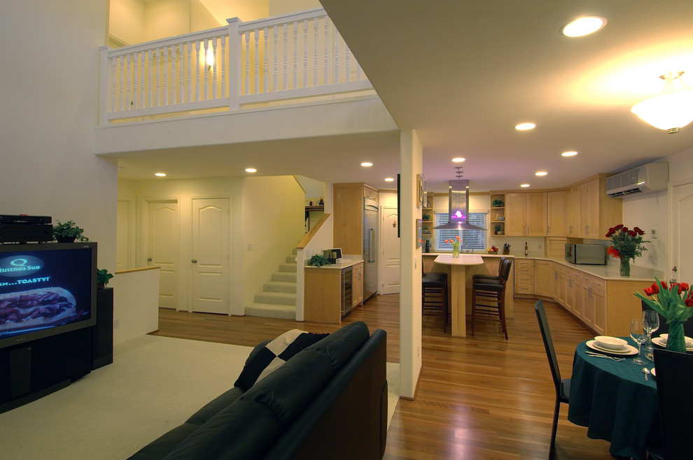 Modelo de sala de estar actual con paredes blancas, suelo de madera en tonos medios, televisor independiente y alfombra