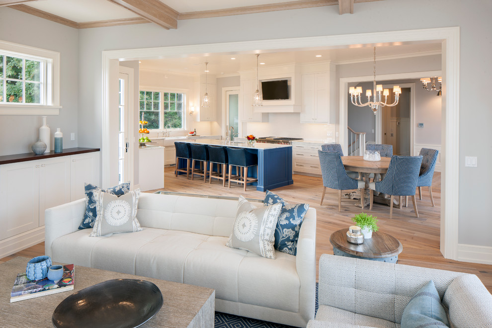 Diseño de sala de estar abierta costera extra grande con paredes grises, suelo de madera clara y suelo marrón