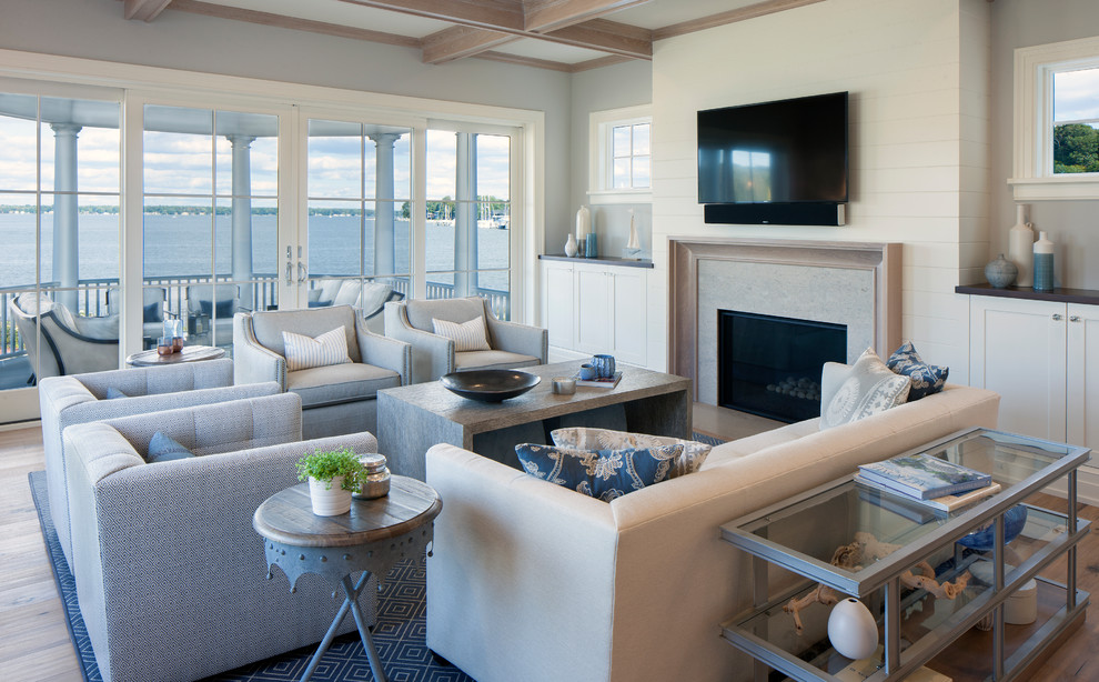 Свежая идея для дизайна: открытая гостиная комната в морском стиле с серыми стенами, светлым паркетным полом, стандартным камином и телевизором на стене - отличное фото интерьера
