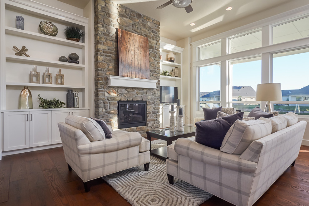 Example of a transitional open concept medium tone wood floor family room design in Boise with beige walls, a standard fireplace, a stone fireplace and a corner tv