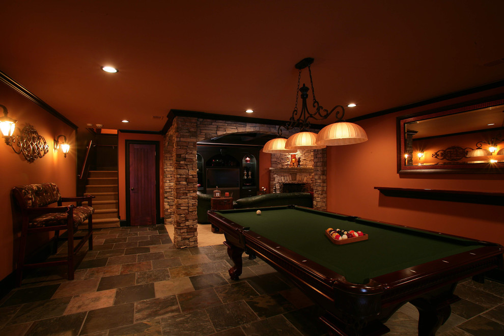Aménagement d'une salle de séjour classique de taille moyenne et ouverte avec salle de jeu, un mur orange, un sol en ardoise, un sol multicolore, une cheminée d'angle, un manteau de cheminée en pierre et un téléviseur encastré.