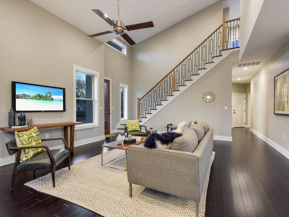Immagine di un soggiorno moderno di medie dimensioni e aperto con pareti grigie, parquet scuro, TV a parete e pavimento marrone