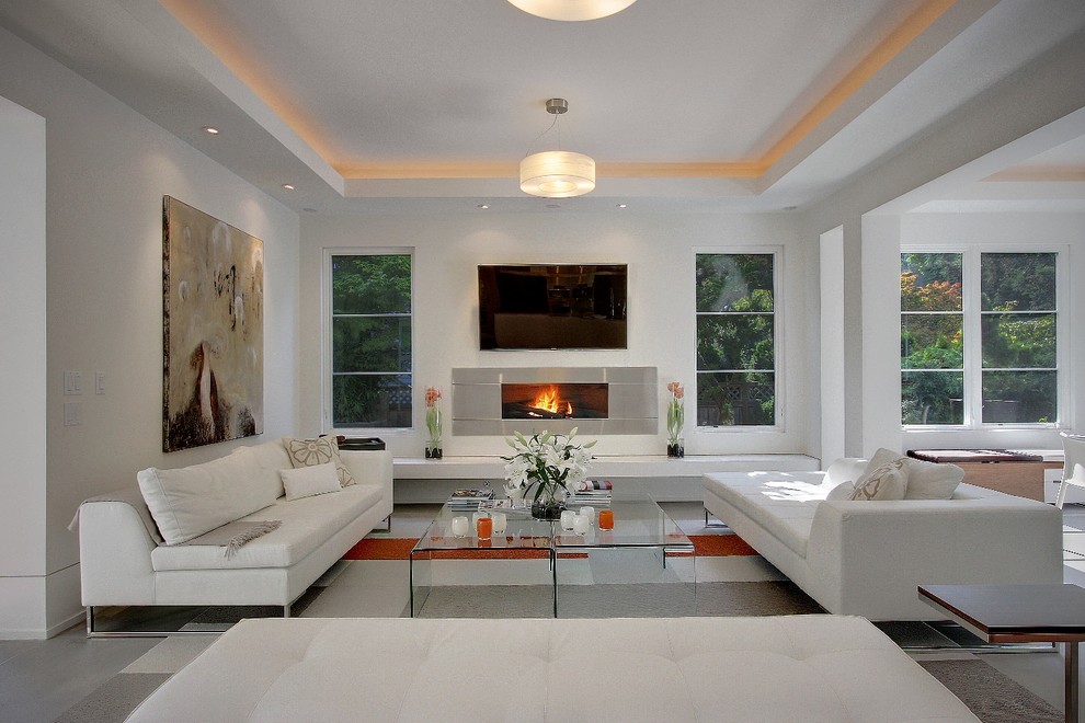 This is an example of a medium sized contemporary open plan games room in Seattle with white walls, a wall mounted tv, concrete flooring, a ribbon fireplace, a tiled fireplace surround and grey floors.