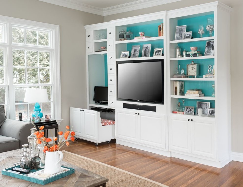 Example of a trendy medium tone wood floor family room design in New York with beige walls and a media wall