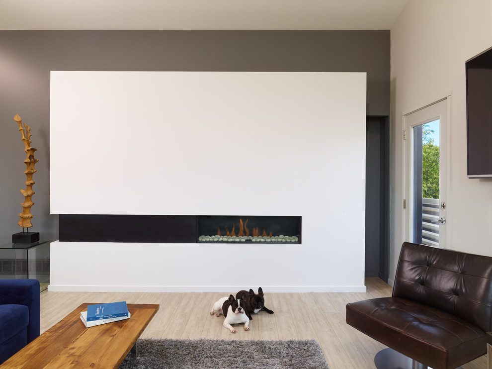 Design ideas for a medium sized contemporary open plan games room in Kansas City with grey walls, laminate floors, a ribbon fireplace, a plastered fireplace surround, a wall mounted tv and beige floors.