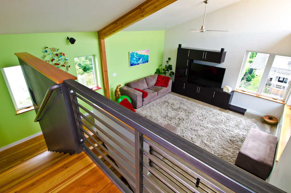 Diseño de sala de estar abierta minimalista grande sin chimenea con paredes verdes, suelo de madera en tonos medios y televisor independiente
