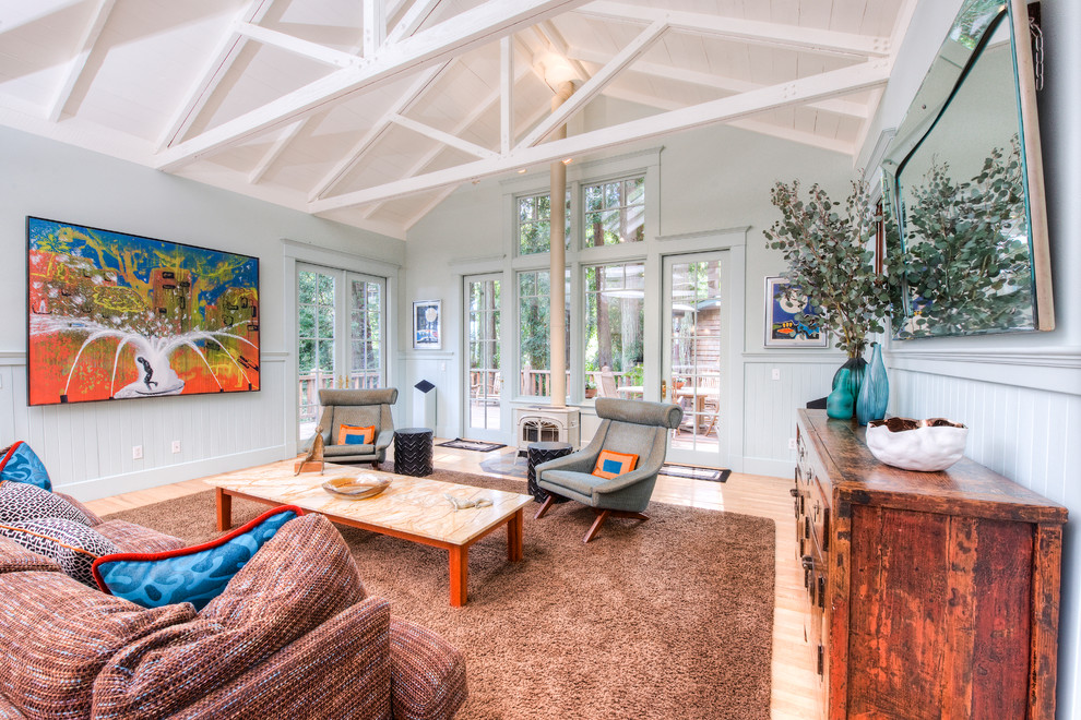 Diseño de sala de estar abierta rústica grande sin televisor con paredes azules y suelo de madera en tonos medios
