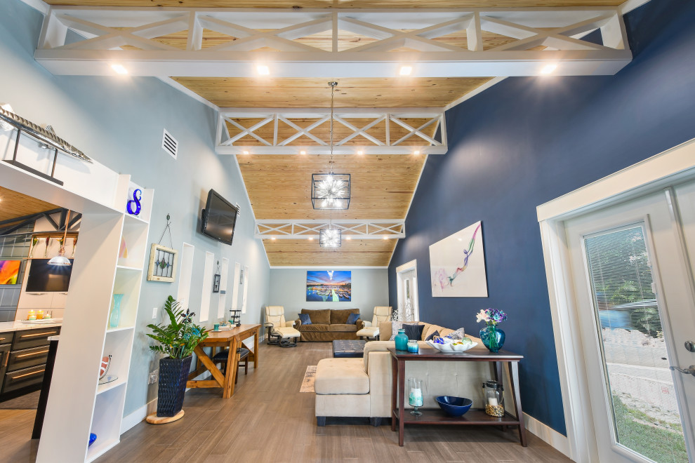 Idée de décoration pour une très grande salle de séjour bohème ouverte avec un mur bleu, parquet en bambou, un téléviseur fixé au mur et un sol marron.