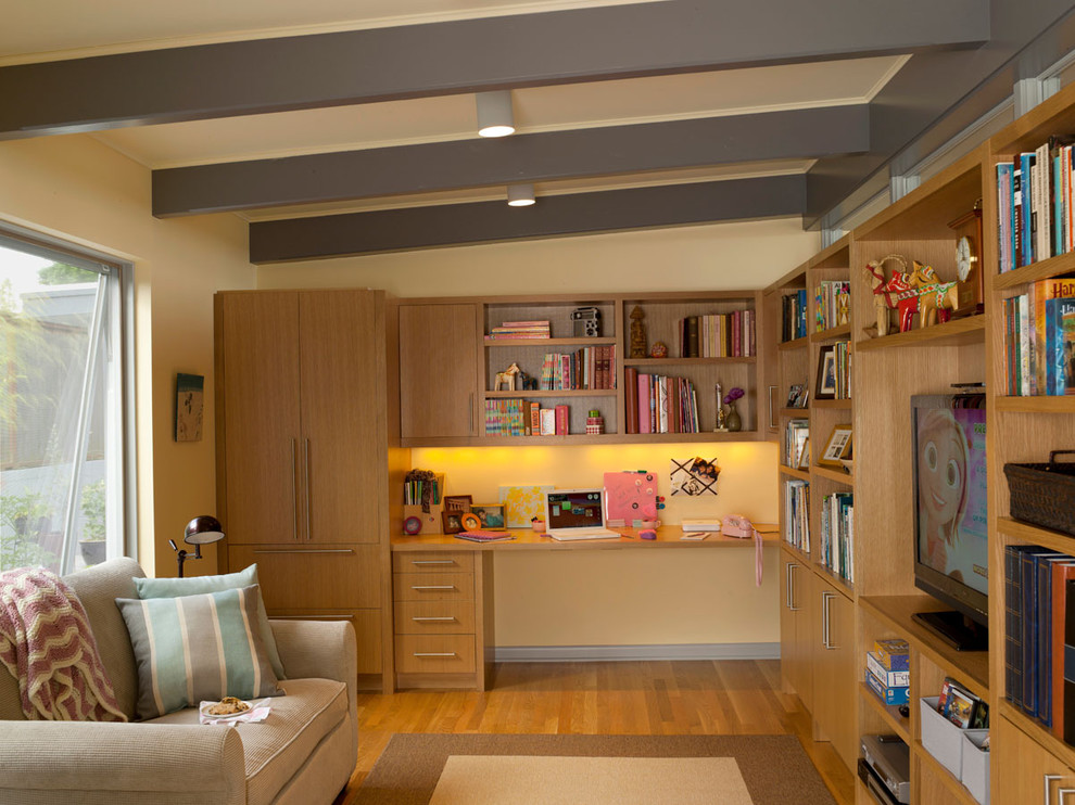 Foto di un soggiorno moderno di medie dimensioni con pareti beige, pavimento in legno massello medio, parete attrezzata, nessun camino e tappeto