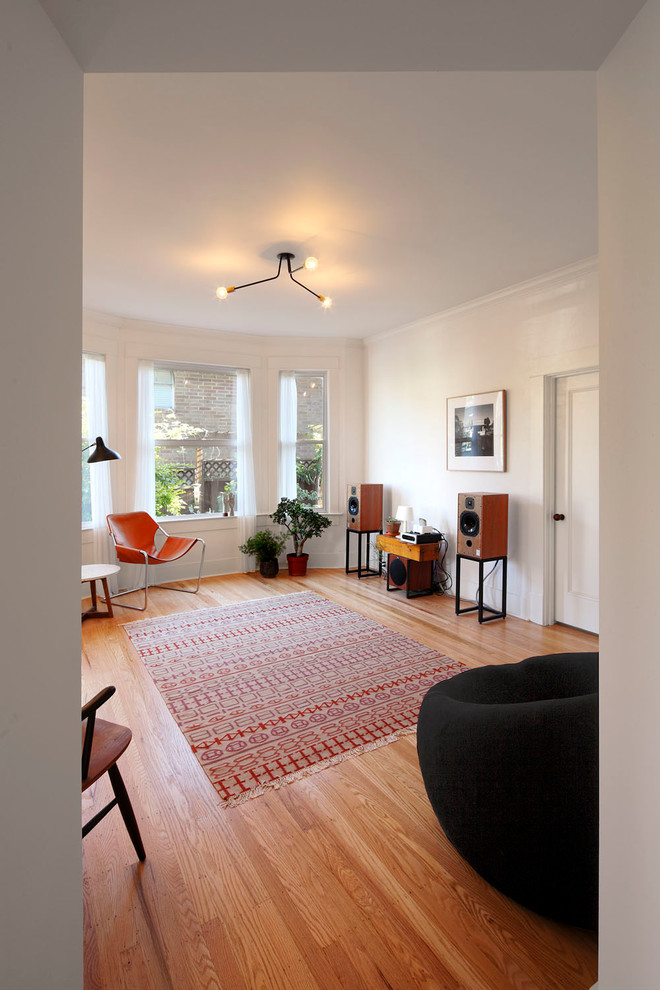Modelo de sala de estar abierta clásica renovada de tamaño medio sin chimenea y televisor con paredes blancas, suelo de madera clara y suelo marrón