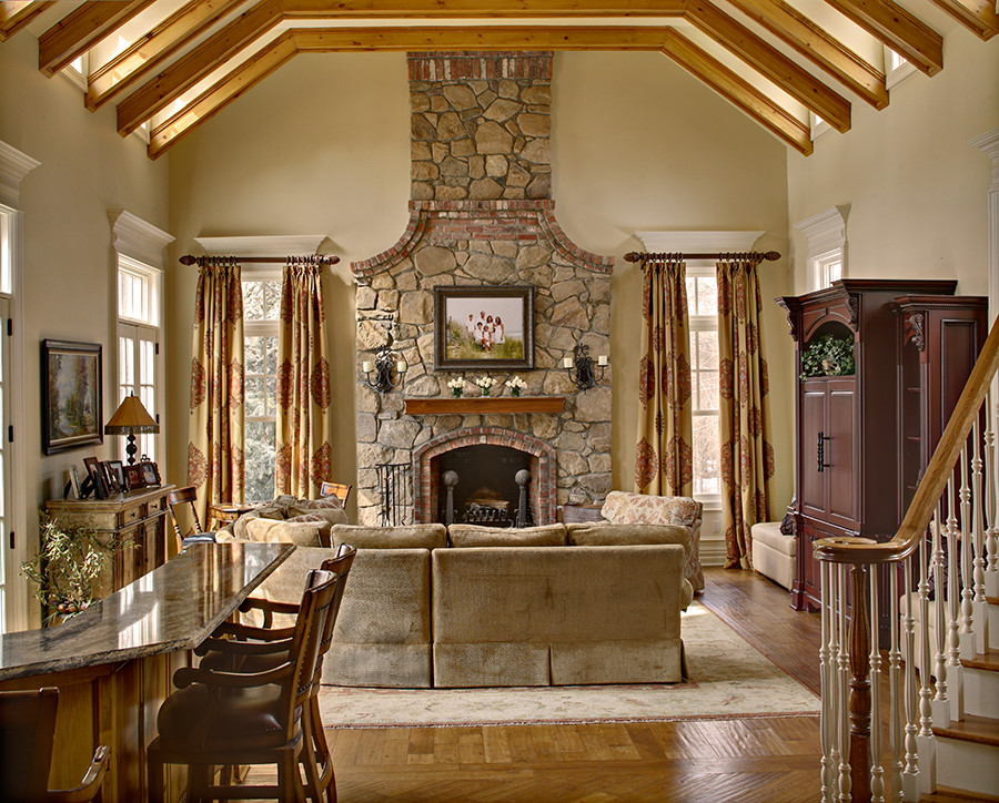 Expansive traditional open plan games room in New York with light hardwood flooring, a standard fireplace, a stone fireplace surround, a concealed tv and beige walls.