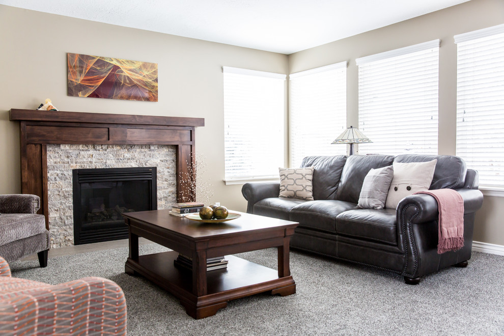Ejemplo de sala de estar abierta tradicional renovada de tamaño medio con paredes beige, moqueta, todas las chimeneas, marco de chimenea de piedra, televisor independiente y suelo gris