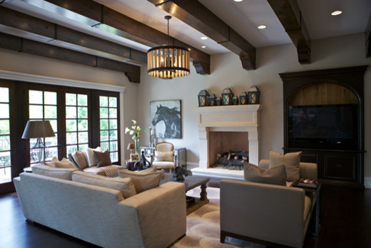 Modelo de sala de estar abierta clásica grande con paredes grises, suelo de madera oscura, marco de chimenea de piedra y pared multimedia