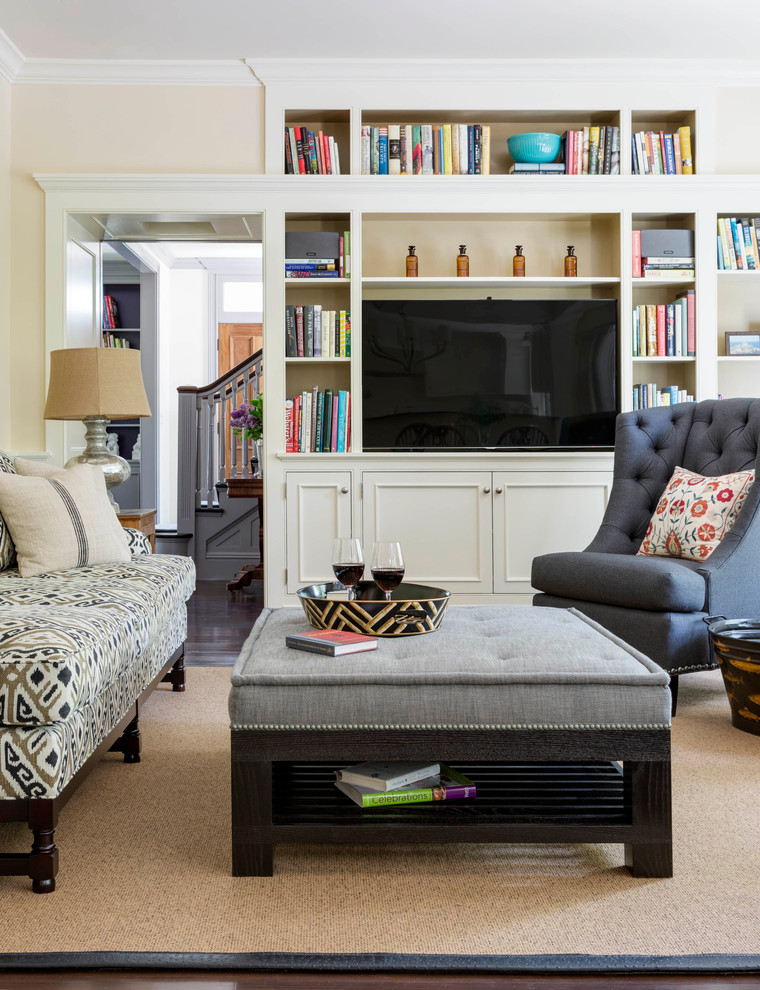Cette image montre une grande salle de séjour traditionnelle ouverte avec un mur beige, parquet foncé et un téléviseur encastré.