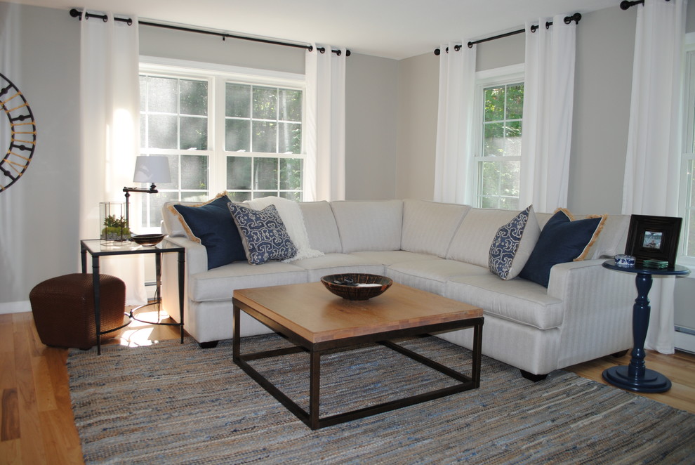 Example of a mid-sized transitional enclosed medium tone wood floor and brown floor family room design in Portland Maine with white walls
