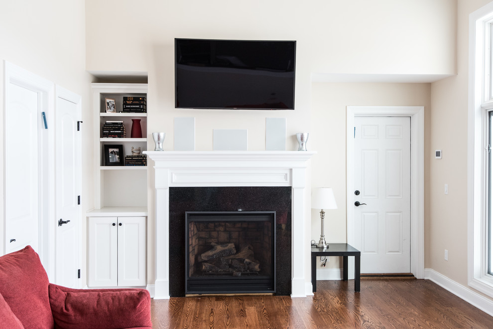 アトランタにあるお手頃価格の中くらいなトラディショナルスタイルのおしゃれな独立型ファミリールーム (ベージュの壁、無垢フローリング、標準型暖炉、タイルの暖炉まわり、壁掛け型テレビ) の写真