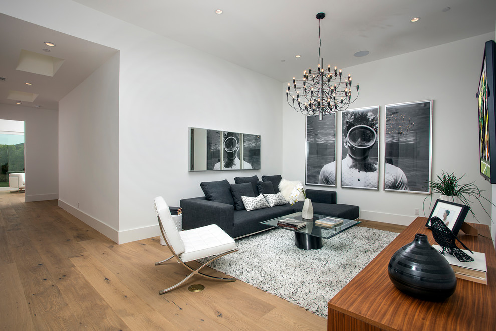 Foto di un grande soggiorno moderno aperto con pareti bianche, pavimento in legno massello medio, pavimento marrone e TV a parete