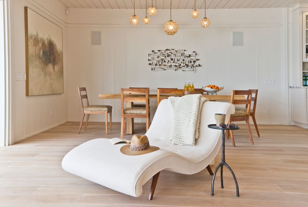 Aménagement d'une salle à manger bord de mer avec un mur blanc et parquet clair.