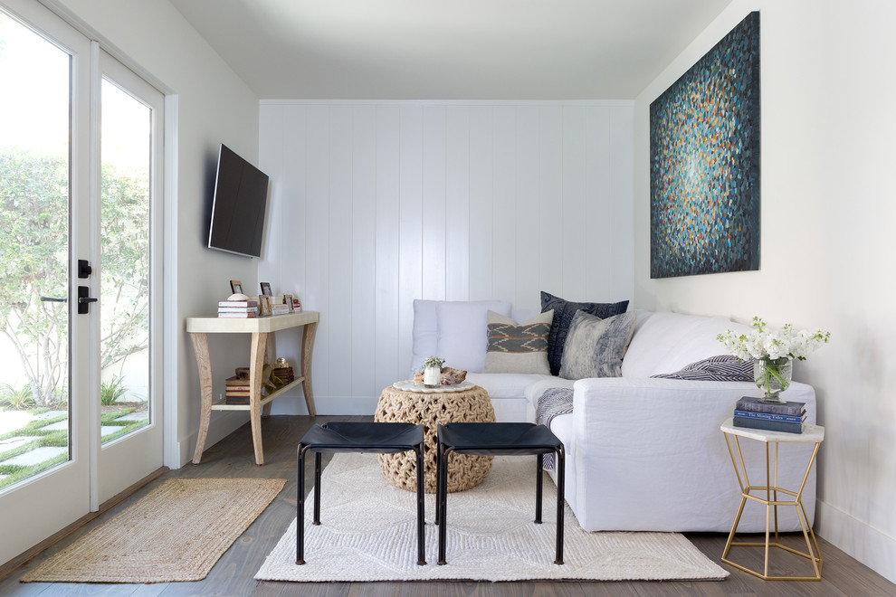Idee per un piccolo soggiorno costiero con pareti bianche, parquet scuro, TV a parete, pavimento marrone e tappeto