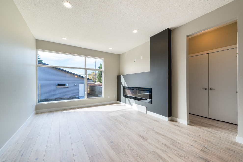 Mittelgroßes, Offenes Modernes Wohnzimmer mit weißer Wandfarbe, Laminat, Kamin und braunem Boden in Edmonton