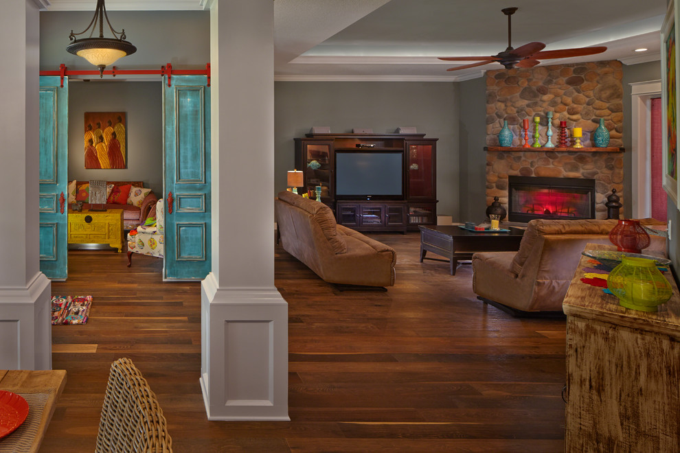 Mittelgroßes, Offenes Eklektisches Wohnzimmer mit grauer Wandfarbe, braunem Holzboden, Kamin, Kaminumrandung aus Stein und Multimediawand in Miami