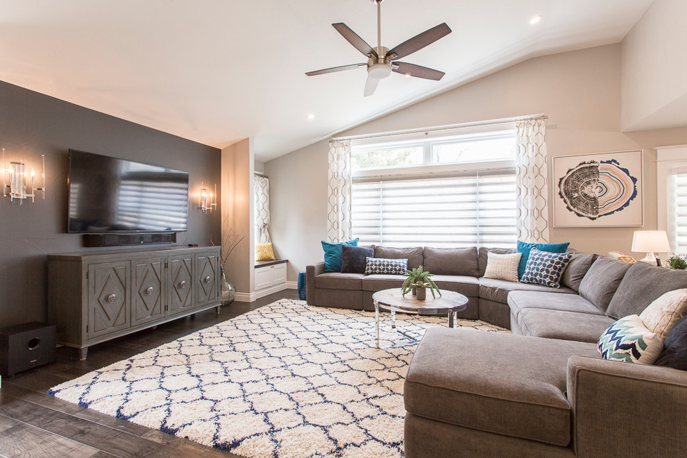 Immagine di un grande soggiorno classico aperto con pareti grigie, pavimento in legno massello medio, TV a parete e pavimento marrone