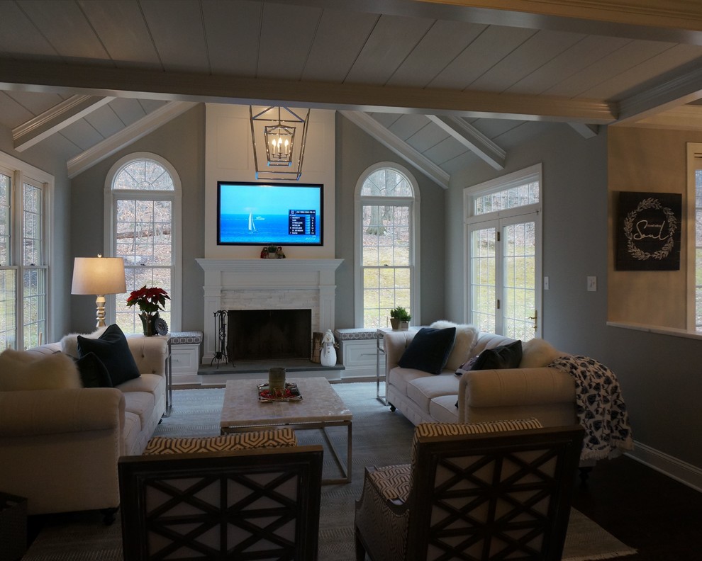 Идея дизайна: открытая гостиная комната среднего размера в стиле неоклассика (современная классика) с серыми стенами, темным паркетным полом, стандартным камином, фасадом камина из дерева, телевизором на стене и коричневым полом