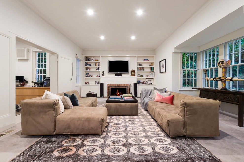 Immagine di un soggiorno chic aperto con pareti bianche, camino classico, cornice del camino in mattoni, TV a parete e pavimento grigio
