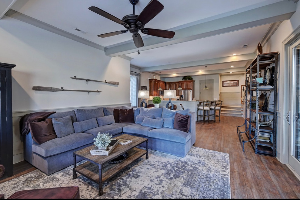 Inspiration for a large timeless open concept vinyl floor, brown floor and exposed beam family room remodel in Charlotte with a bar, gray walls and a wall-mounted tv