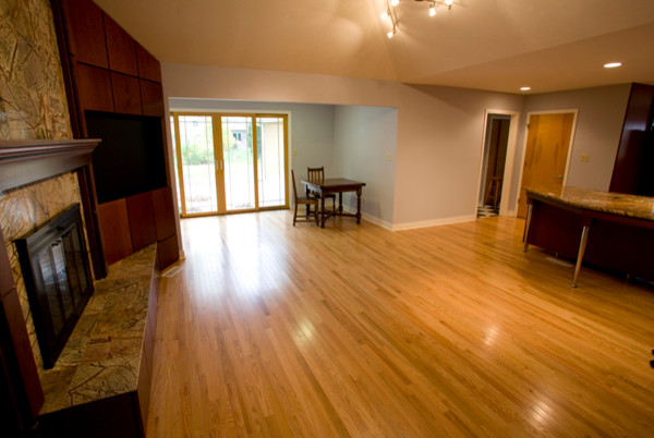 Inspiration pour une grande salle de séjour traditionnelle ouverte avec un mur beige, parquet clair et une cheminée standard.