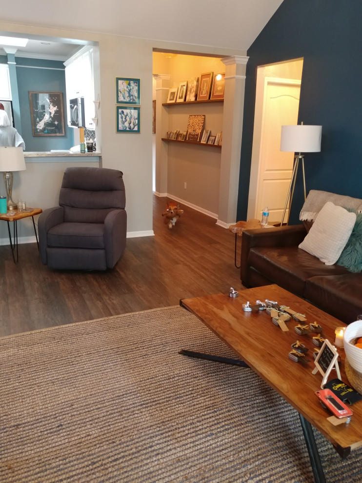 Immagine di un soggiorno tradizionale con pareti blu, pavimento in vinile e pavimento marrone