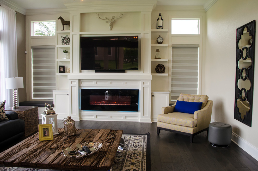 Immagine di un grande soggiorno classico aperto con pareti beige, cornice del camino in legno, TV a parete e parquet scuro