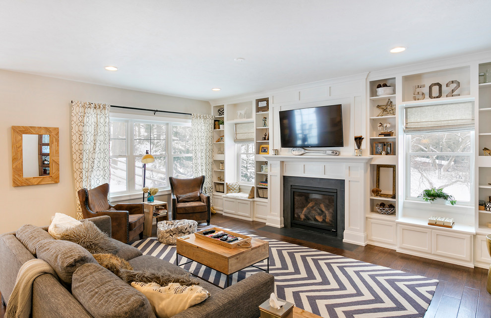 Immagine di un grande soggiorno american style chiuso con sala giochi, pareti beige, pavimento in legno massello medio, camino classico e TV a parete