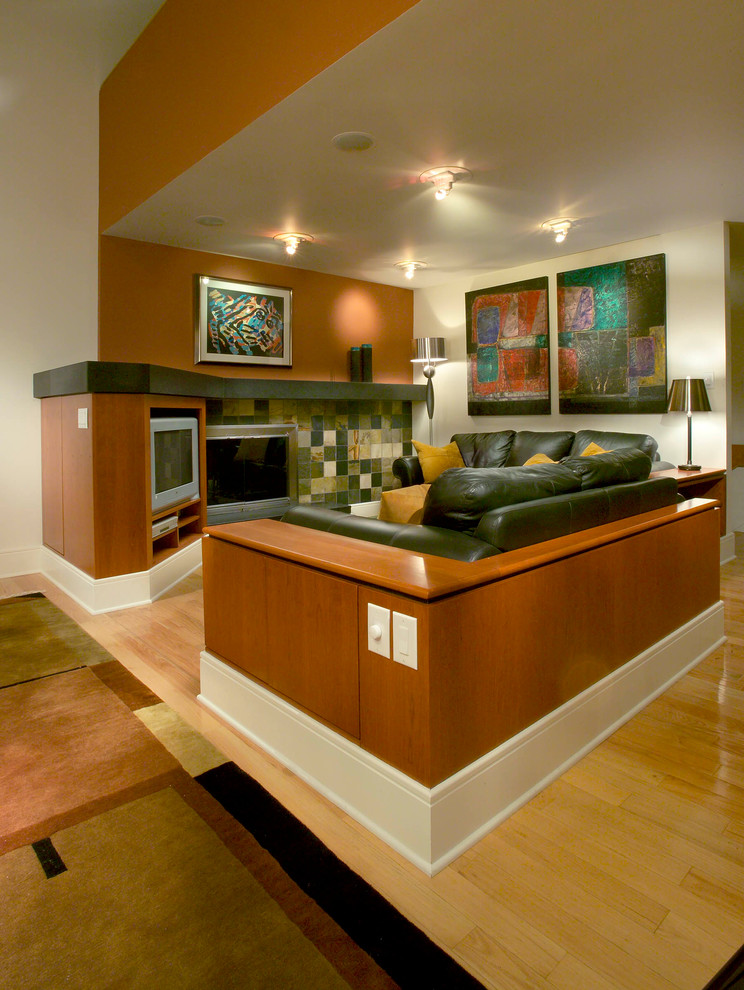 На фото: двухуровневая гостиная комната среднего размера в современном стиле с белыми стенами, светлым паркетным полом, стандартным камином и телевизором в углу