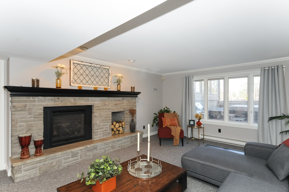 Aménagement d'une grande salle de séjour contemporaine ouverte avec un mur gris, moquette, une cheminée standard, un manteau de cheminée en pierre et aucun téléviseur.
