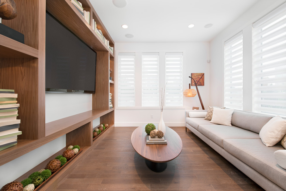 Contemporary games room in Calgary with white walls, dark hardwood flooring and a built-in media unit.