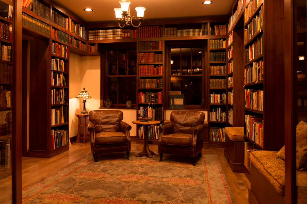 Foto di un soggiorno stile americano di medie dimensioni e chiuso con libreria, pareti beige, pavimento in legno massello medio e nessuna TV